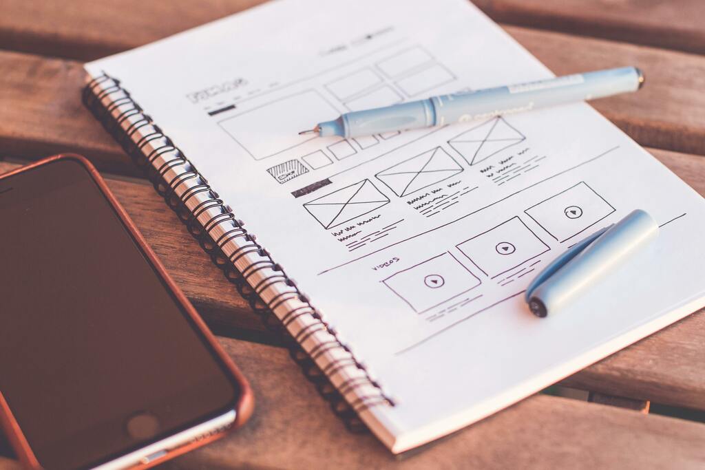 Design notebook beside a phone on a desk